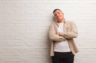 Genç latin adam kendine güvenen ve kollarını kavuşturan, yukarı bakan