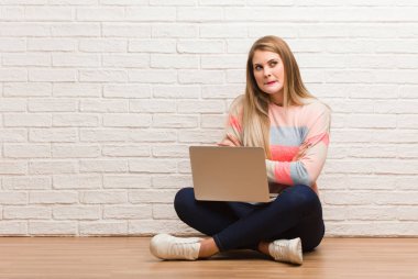 Kollarını kavuşturarak oturan genç Rus öğrenci kadın.