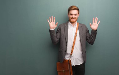 Genç kızıl saçlı iş adamı on numarayı gösteriyor.
