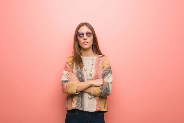 Young hippie woman on pink background tired and bored