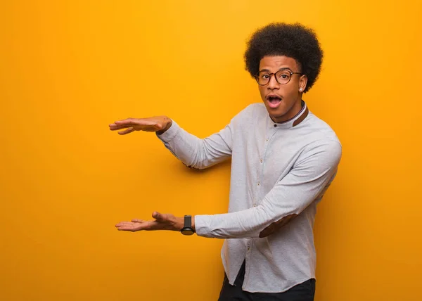 Giovane Uomo Afroamericano Sopra Muro Arancione Con Qualcosa Molto Sorpreso — Foto Stock