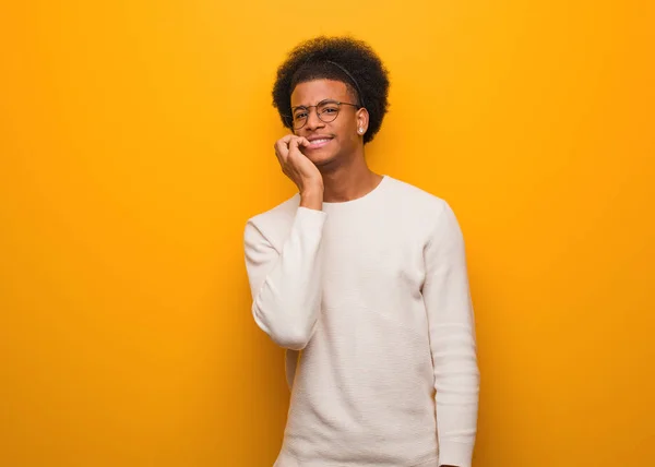 Jeune Homme Afro Américain Sur Mur Orange Mordant Des Ongles — Photo