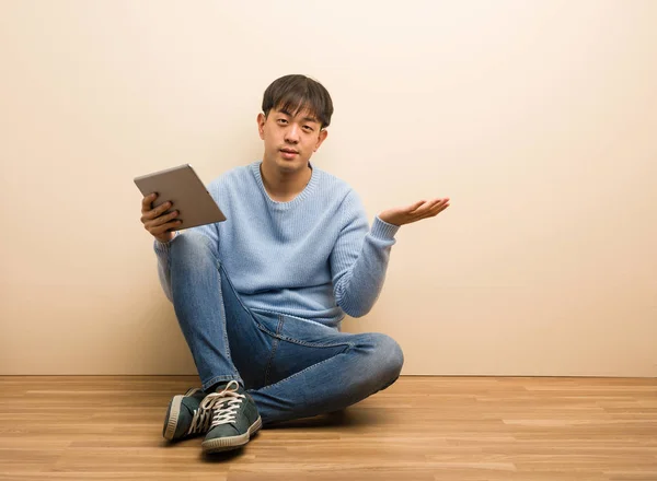 Jovem Chinês Sentado Usando Seu Tablet Segurando Algo Com Mão — Fotografia de Stock