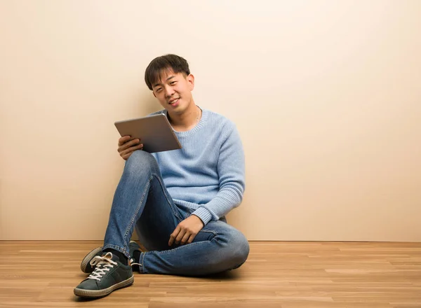 Jovem Chinês Sentado Usando Seu Tablet Cruzando Braços Sorrindo Relaxado — Fotografia de Stock