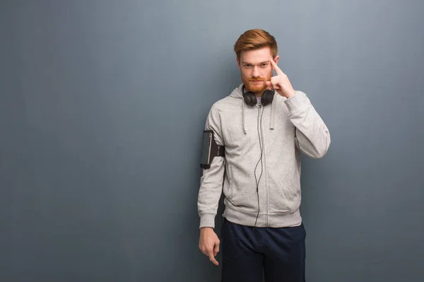Young fitness redhead man thinking about an idea