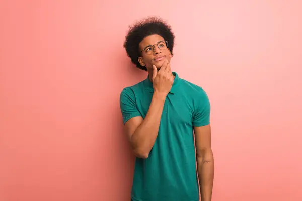Jovem Homem Afro Americano Sobre Uma Parede Rosa Duvidosa Confusa — Fotografia de Stock
