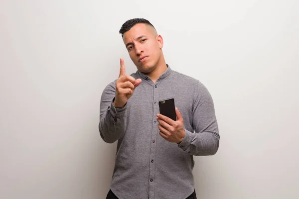 Joven Latino Sosteniendo Teléfono Mostrando Número Uno — Foto de Stock