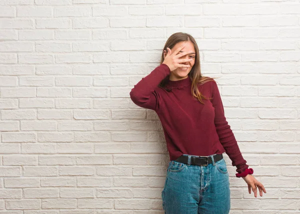 Young cool woman over a bricks wall embarrassed and laughing at the same time