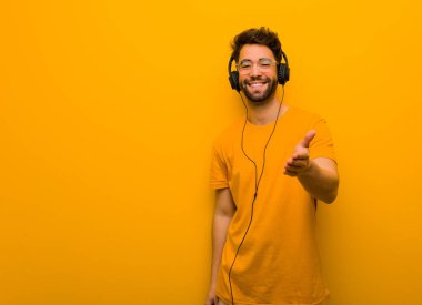 Genç adam müzik dinliyor. Birini selamlamak için uzanıyor.