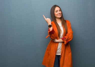 Genç, doğal bir kadın parmaklarıyla kenarı işaret ediyor.