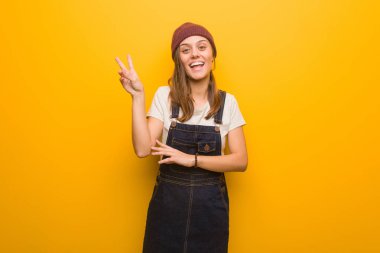 Genç hippi kadın zafer jesti yapıyor.