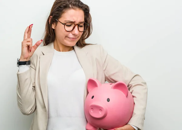 Joven Empresaria Europea Sosteniendo Una Alcancía Cruzando Los Dedos Para — Foto de Stock