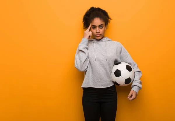 Молодая Темнокожая Женщина Делает Концентрированный Жест Холдинг Футбольный Мяч — стоковое фото