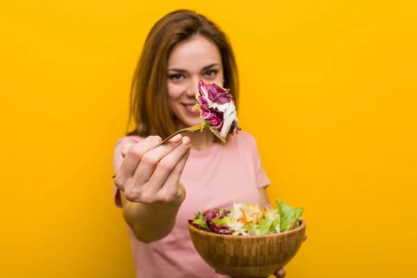 Vegan young woman eating a fresh and delicious salad.