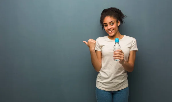 Genç Siyah Kadın Gülümsüyor Yan Tarafı Işaret Ediyor Elinde Bir — Stok fotoğraf