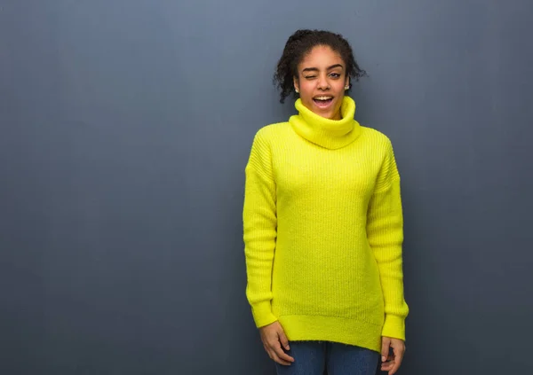 Young black woman winking, funny, friendly and carefree gesture