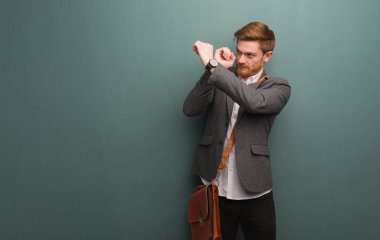 Genç kızıl saçlı işadamı dürbün hareketi yapıyor.