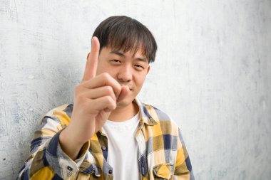 Genç Çinli adamın yüzü bir numarayı gösteriyor.