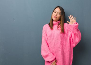 Genç modern kadın 5 numarayı gösteriyor.