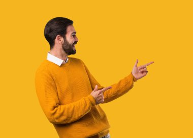 Genç, doğal bir adam parmağıyla kenarı işaret ediyor.