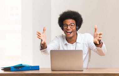 Genç tele pazarlamacı siyahi adam ön tarafa sarılmaktan çok mutlu.