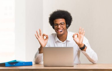 Genç pazarlamacı siyah adam yoga yapıyor.