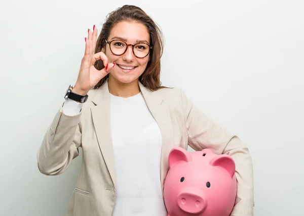 Joven Empresaria Europea Sosteniendo Una Alcancía Alegre Confiada Mostrando Gesto — Foto de Stock