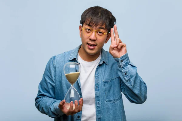 Young Chinese Man Holding Sand Timer Fun Happy Doing Gesture — 스톡 사진