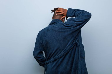 Arkasından pijama giyen Afrikalı genç bir adam bir şey düşünüyor..