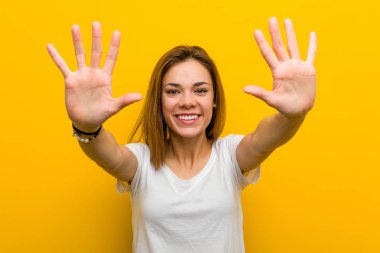 Young natural caucasian woman showing number ten with hands.