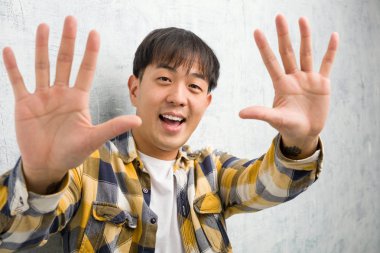 On numarayı gösteren genç Çinli bir adam.