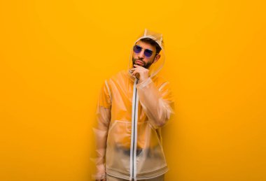 Bir fikir hakkında düşünen bir yağmur ceket giyen genç adam