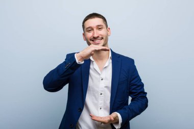 Genç beyaz adam iki eliyle bir şey tutuyor, ürün sunumu..