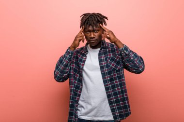 Genç Afrikalı siyahi adam bir göreve odaklanmış, onu parmağıyla işaret ediyor..