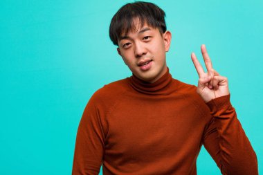 Genç Çinli iki numarayı gösteriyor.