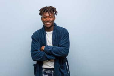 Genç Afrikalı siyah adam pijama giyip gülüyor ve eğleniyor..