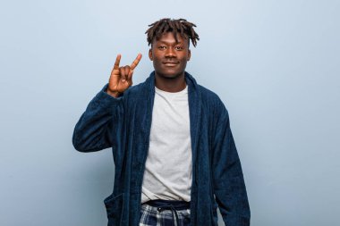 Genç Afrikalı siyah adam pijama giyip boynuzlarını gösteriyor devrim konsepti olarak..