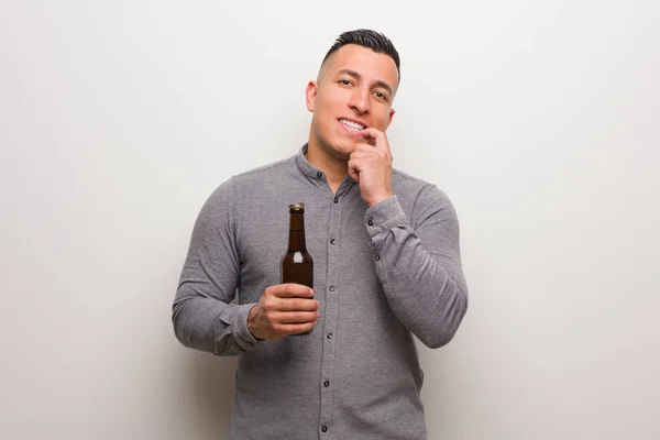 Mladý Latinský Muž Držící Pivo Uvolnil Při Pomyšlení Něco Dívá — Stock fotografie