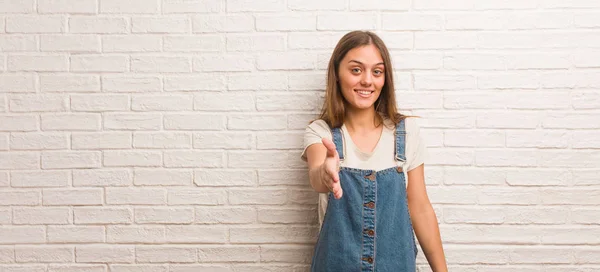 Young hipster woman reaching out to greet someone
