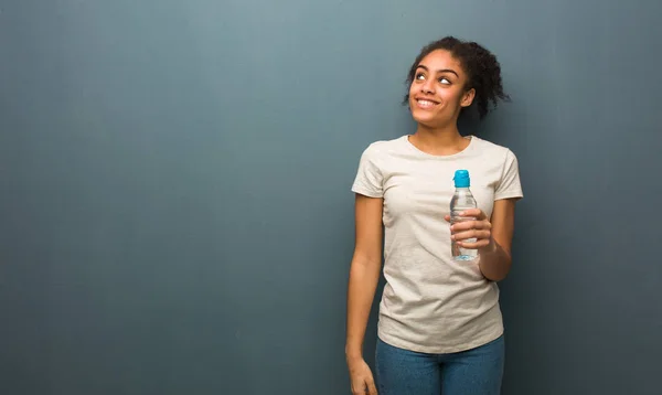 Молодая Черная Женщина Мечтает Достижении Целей Целей Держит Бутылку Водой — стоковое фото