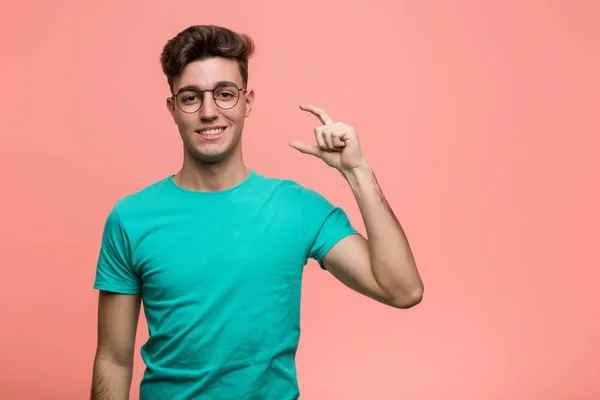 Young Cool Caucasian Man Holding Something Little Forefingers Smiling Confident — 스톡 사진