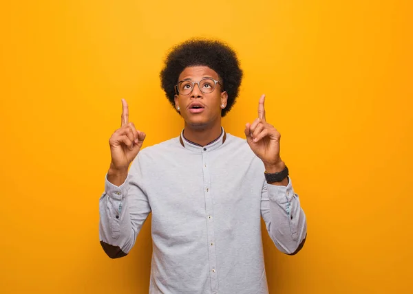 Jovem Afro Americano Sobre Uma Parede Laranja Surpreso Apontando Para — Fotografia de Stock