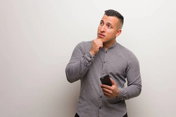 Jeune Homme Latino Tenant Téléphone Détendu Penser Quelque Chose Regardant — Photo