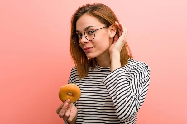 Mujer Joven Sosteniendo Una Dona Tratando Escuchar Chisme —  Fotos de Stock