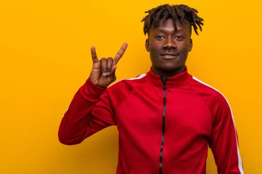 Genç fitness siyah adam boynuzlarını gösteriyor devrim konsepti olarak jest.
