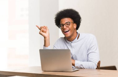 Genç siyah adam parmak ile yan işaret dizüstü bilgisayarını kullanarak