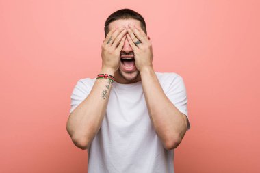 Genç adam elleriyle gözlerini kapatıyor, gülümseyerek bir sürpriz bekliyor..