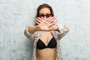 Bikini giyen genç Avrupalı kadın inkar jesti yapıyor.