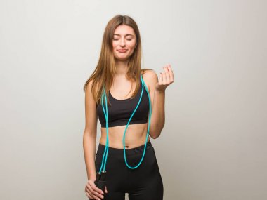 Genç fitness Rus kadın bir ihtiyaç jesti yapıyor. Atlama halatı tutuyorum..