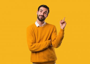 Genç, doğal bir adam parmağıyla kenarı işaret ediyor.